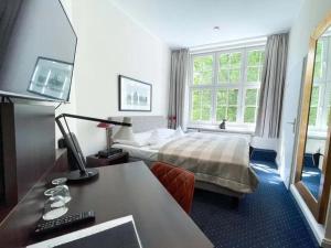 a hotel room with a bed and a desk at Hotel Wagner im Dammtorpalais in Hamburg