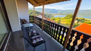 a balcony with chairs and a view of a river at Apartmani Rama - terra nostra in Prozor