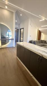 eine Küche und ein Wohnzimmer mit Sofa und Tisch in der Unterkunft Elite Residence - Koura , Near Tripoli in An Nakhlah + 62 Fotos