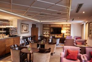 a restaurant with tables and chairs and a flat screen tv at The Marble Arch Hotel, by Thistle in London