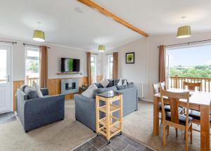 a living room with couches and a dining room at Meadow Lakes Holiday Park in St Austell +170 photos