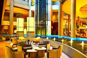 a lobby with chairs and tables in a building at Hotel Manurita Palace in Dhanbād