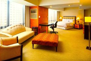 a hotel room with a bed and a desk at Hotel Manurita Palace in Dhanbād