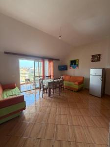 a living room with a table and chairs and a kitchen at Apartament Golem in Golem +2 photos