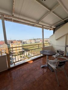 a balcony with a table and chairs and a large window at Apartament Golem in Golem