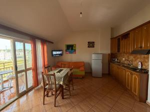 a kitchen and dining room with a table and chairs and a kitchen with a couch at Apartament Golem in Golem