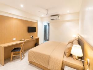 a hotel room with a bed and a desk at The Zenith Luxuary in Patna