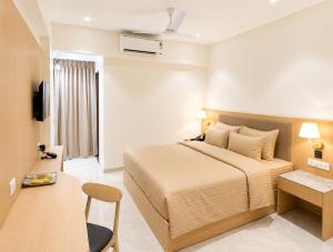 a hotel room with a bed and a television at The Zenith Luxuary in Patna