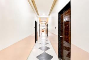 a hallway with black and white tile floors and doors at The Zenith Luxuary in Patna