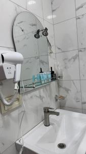 a bathroom with a sink with a phone and a mirror at Ord INN in Oni