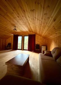 a living room with a couch and a wooden ceiling at Ord INN in Oni