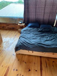 a bed with a canopy in a room with a wooden floor at Thông house 2 in Kon Von Kla