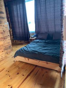 a bedroom with a bed with a wooden floor at Thông house 2 in Kon Von Kla