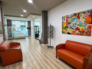 a living room with orange furniture and a painting on the wall at Hotel Elite Palermo Centro in Palermo