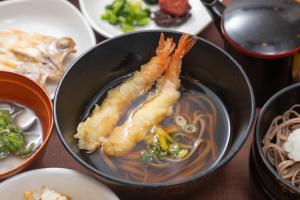 a bowl of soup with a piece of food in it at Dormy Inn Express Matsue in Matsue +17 photos
