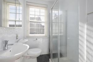 a bathroom with a toilet and a sink and a shower at Copeland House 4 Island Wall in Whitstable +4 photos