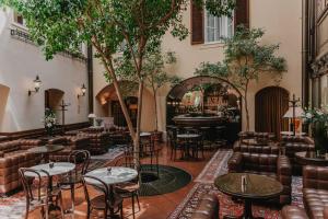 a hotel lobby with tables and chairs and a piano at Hotel König von Ungarn in Vienna