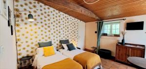 a bedroom with two beds with yellow and white sheets at Terre et Eau Les chambres d'hotes B&B Sèvremont in La Flocellière