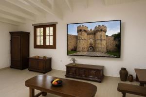 a living room with a picture of a castle on the wall at Terinikos Sunny Garden Hotel & Junior Suites in Ialysos