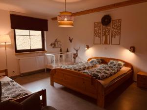 a bedroom with two beds and a crib in it at Chata Santa Claus - Rudolf i Pyszałek GÓRY SOWIE in Sokolec
