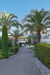 a walkway with palm trees and a building at Royal Mougins Golf, Hotel & Spa de Luxe in Mougins
