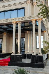 a building with columns and a red carpet at Istanbul Palace Hotel in Urganch