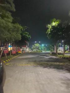 an empty street at night with trees and lights at Apartemen Gresik in Panggang +7 photos
