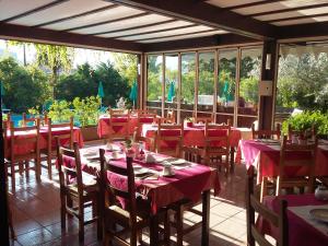 a restaurant with tables and chairs with red table cloth at Residence Concaverde in Pomarolo