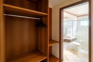 a bathroom with a glass door leading to a sink at Hotel Nova York in Araçatuba +63 photos