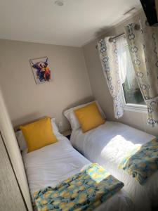two beds in a small room with a window at Caravan no 69 in Cwm-y-glo +44 photos