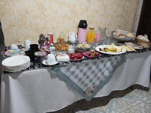 a table with a buffet of food on it at Quartos da Cida in Foz do Iguaçu