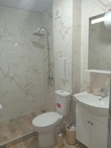 a white bathroom with a toilet and a sink at Kristan in Sveti Vlas +64 photos