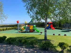 a playground in a park with a tree at Complex Turistic Comoara Bucovinei in Corlata