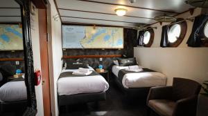 a room with two beds and a map on the wall at Passengerschip Princesse Royal in Groningen