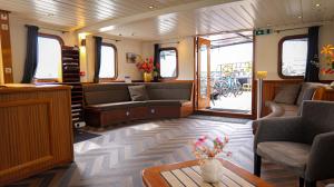 a living room with couches and a table in a train at Passengerschip Princesse Royal in Groningen +3 photos