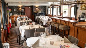 a restaurant with tables and chairs and a bar at Passengerschip Princesse Royal in Groningen