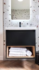 a bathroom with a sink and a pile of towels at Birch Tree Lodge - Luxurious Lodge on the NC500 by Thrumster Lodges in Wick +52 photos