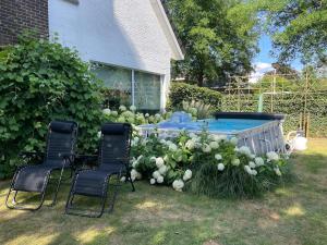 a backyard with a table and chairs and a pool at TML Music Guesthouse in Aartselaar