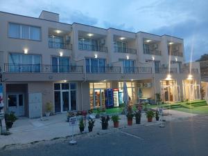 a large white building with plants in front of it at Kristan in Sveti Vlas