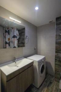 ein Badezimmer mit Waschmaschine und Waschbecken in der Unterkunft Xenophon Studios in Mytilini + 5 Fotos