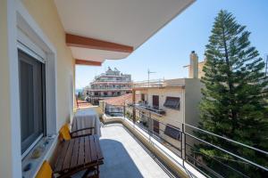 ein Balkon mit einer Bank und einem Baum auf einem Gebäude in der Unterkunft Xenophon Studios in Mytilini