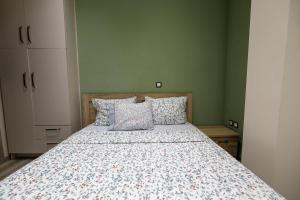 ein Schlafzimmer mit einem Bett mit einer geblümten Tagesdecke in der Unterkunft Xenophon Studios in Mytilini