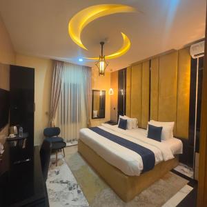a hotel room with a large bed and a chandelier at Classy Castle Hotel And Suite in Ughelli