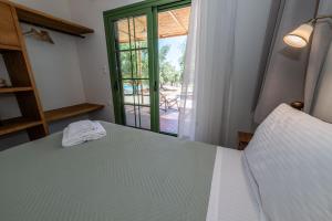 a bedroom with a bed and a sliding glass door at Eleon Olive Retreat - Skourochori in Katakolo +42 photos