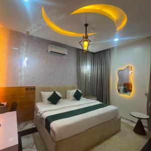 a bedroom with a large bed with a yellow ceiling at Classy Castle Hotel And Suite in Ughelli