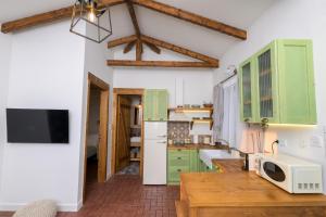 a kitchen with green cabinets and a wooden table at Eleon Olive Retreat - Skourochori in Katakolo