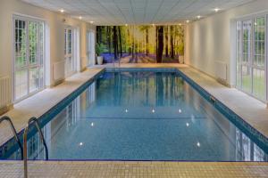 a swimming pool in a house with windows at Forest Lodge Hotel in Lyndhurst