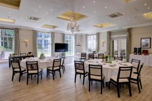 a conference room with tables and chairs and a chandelier at Forest Lodge Hotel in Lyndhurst