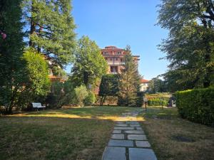 a walkway in a park with a building in the background at La Felce in Cernobbio