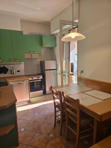 a kitchen with green cabinets and a table and chairs at La Felce in Cernobbio